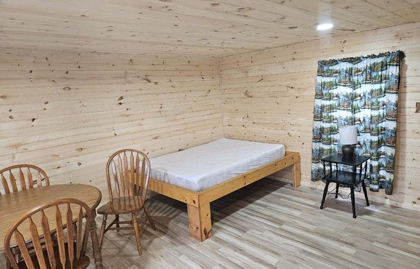 Rustic Cabin interior with single bed and dining area
